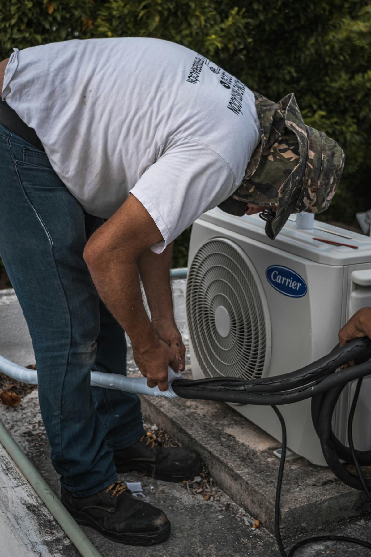 Engineer installing outdoor air conditioning condenser pipework